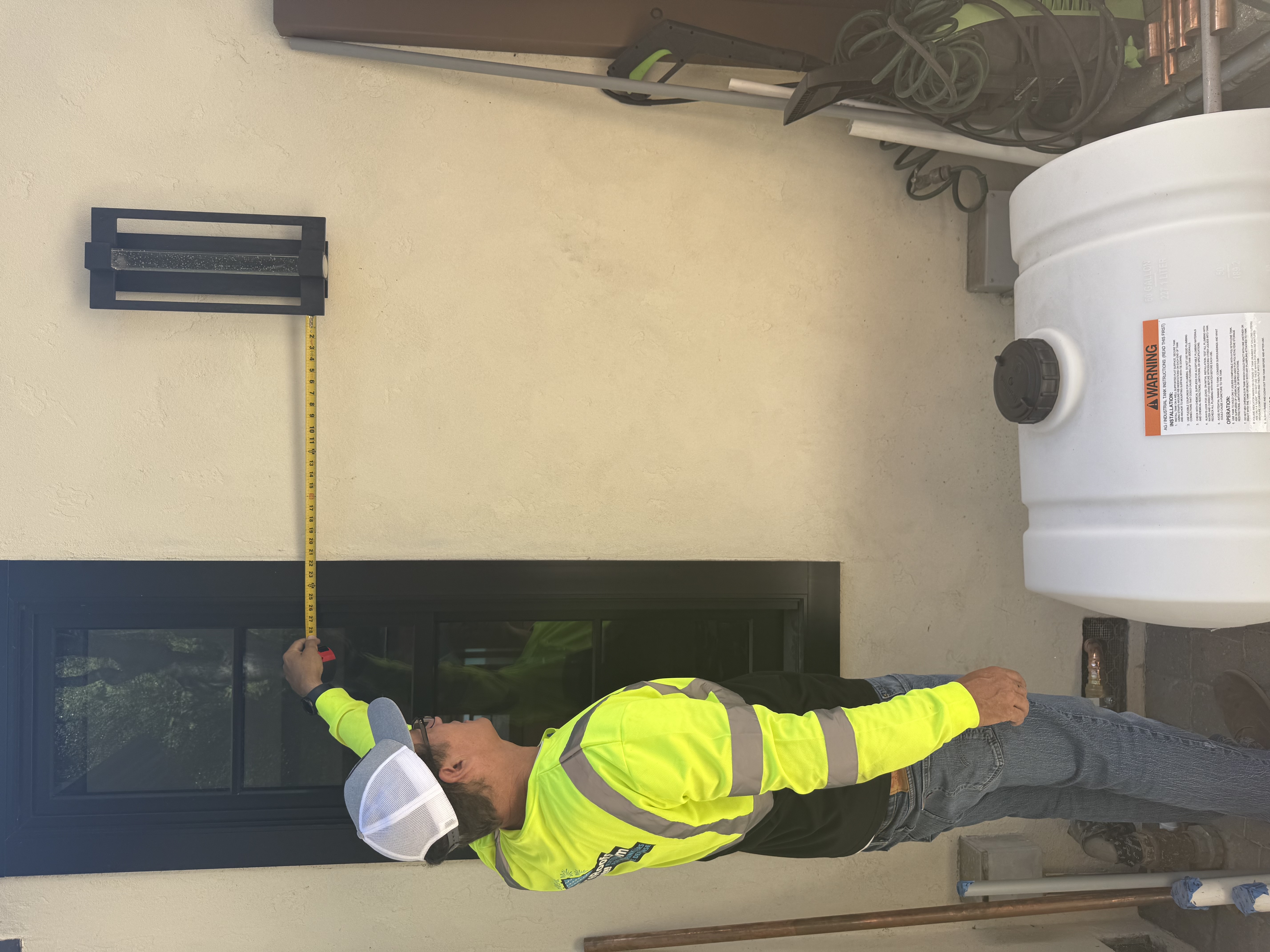 FireRoofs technician measuring for Class A foam tank placement next to exterior wall