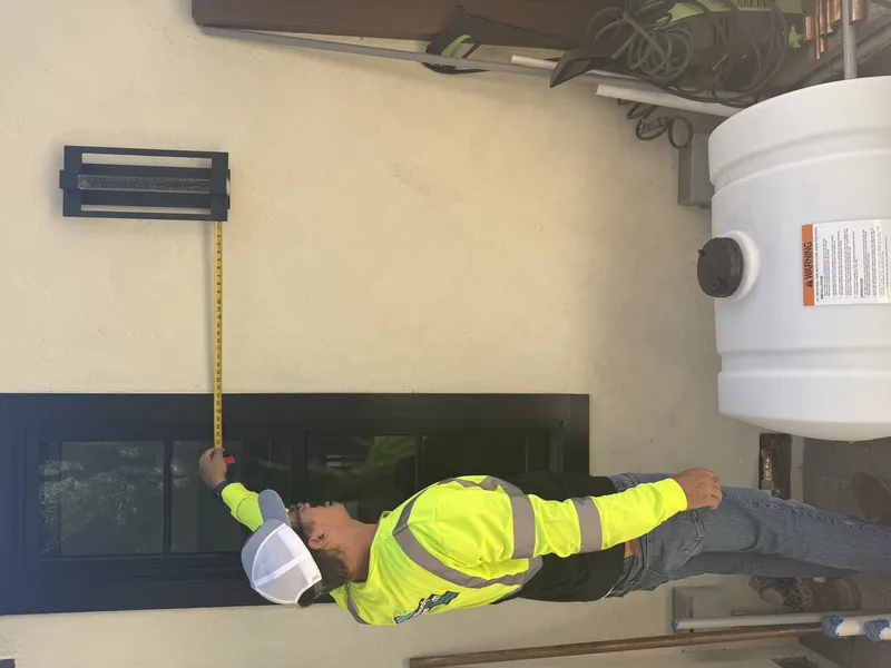 FireRoofs technician measuring for Class A foam tank placement next to exterior wall