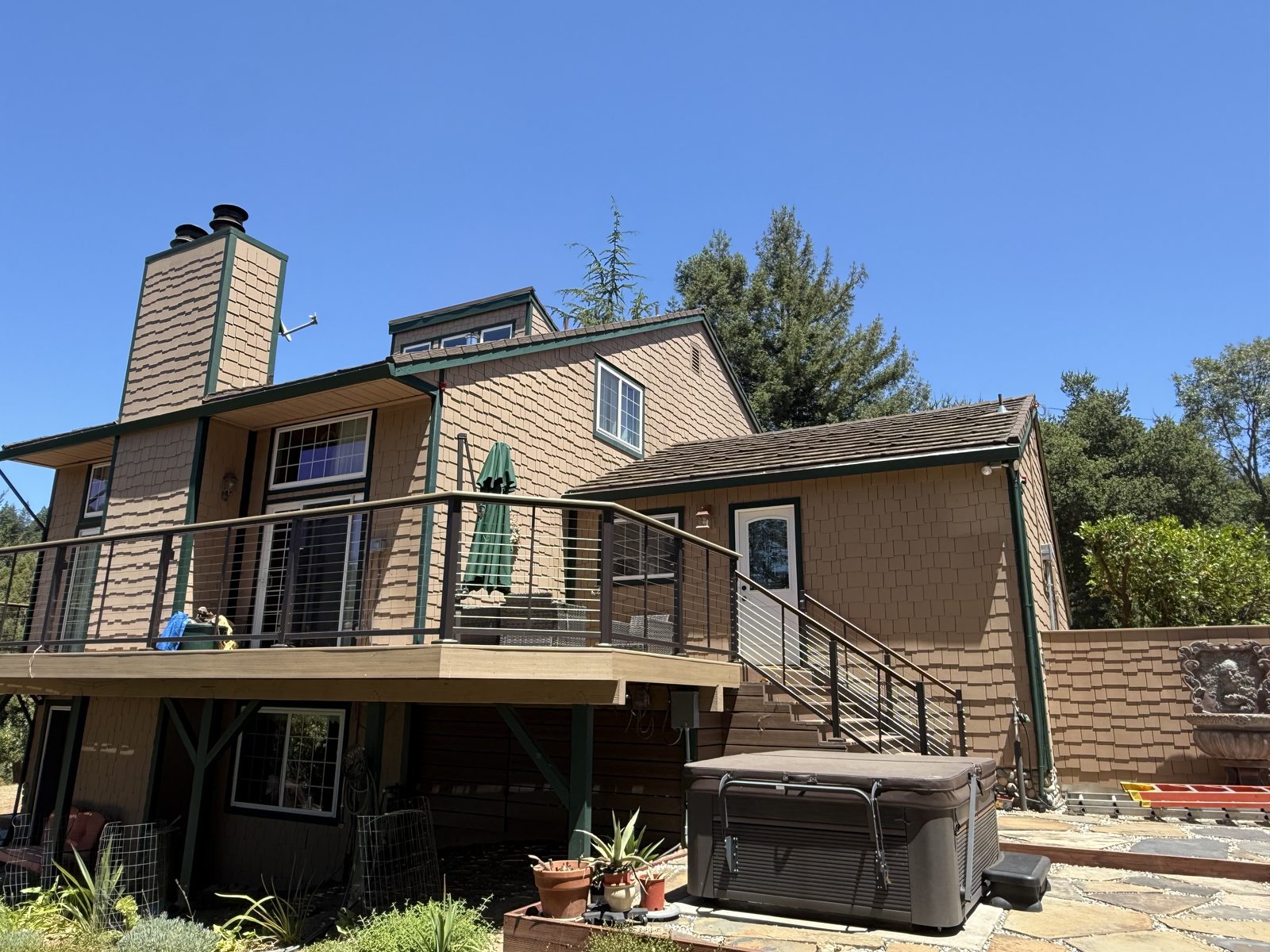 Bay Area home with shingle siding and elevated deck in wildfire-prone wooded terrain, scheduled for Fortress wildfire defense system