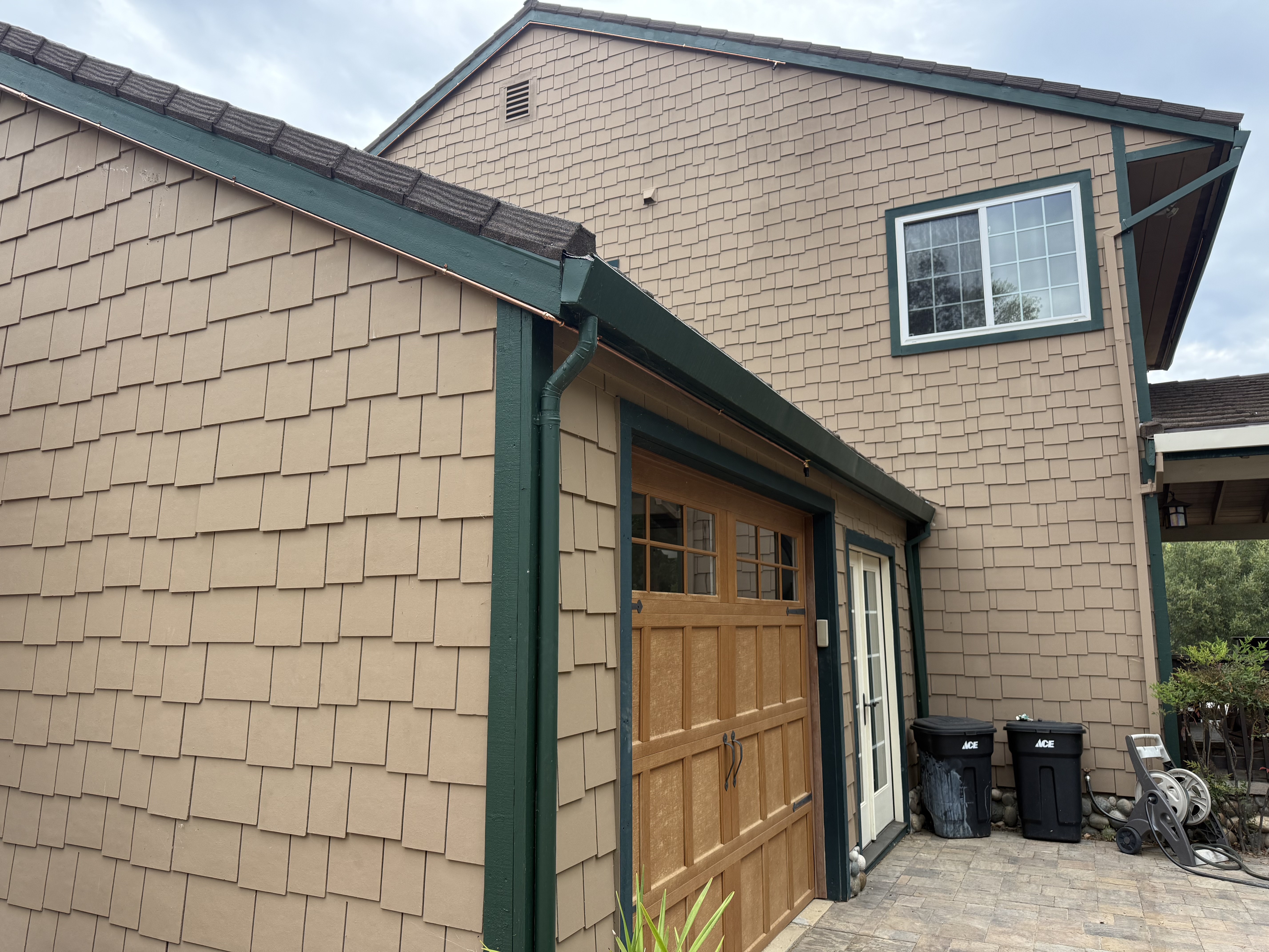 Exterior of a detached garage and office off Summit Road showing copper sprinkler lines along the roofline and eaves