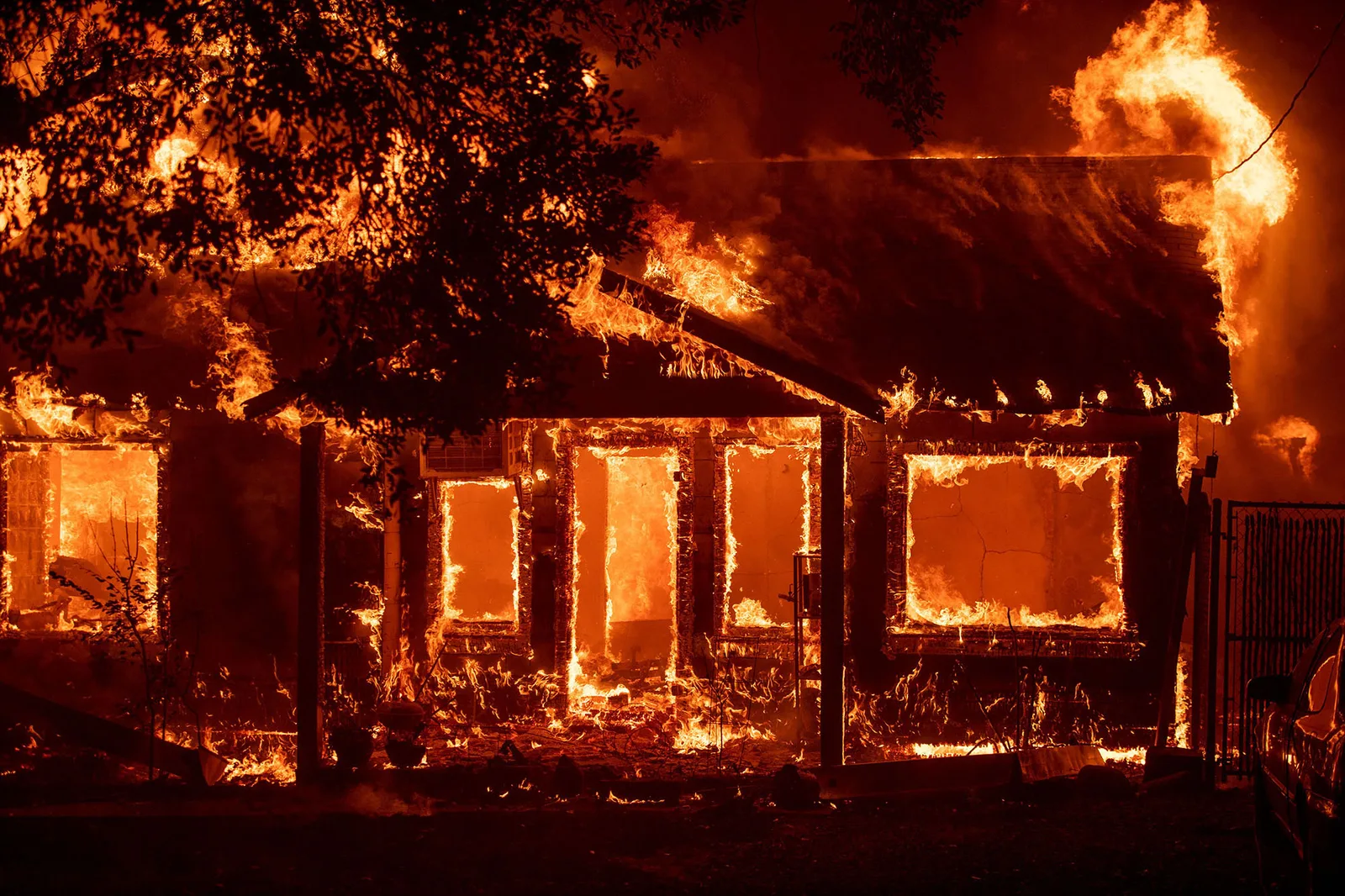 A home engulfed in flames during the 2018 Camp Fire in Paradise, California, which destroyed over 19,000 structures and became the deadliest wildfire in California history